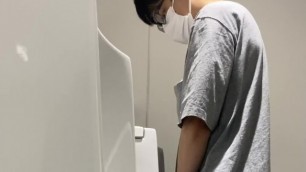 A male student is pissing in the toilet 12.